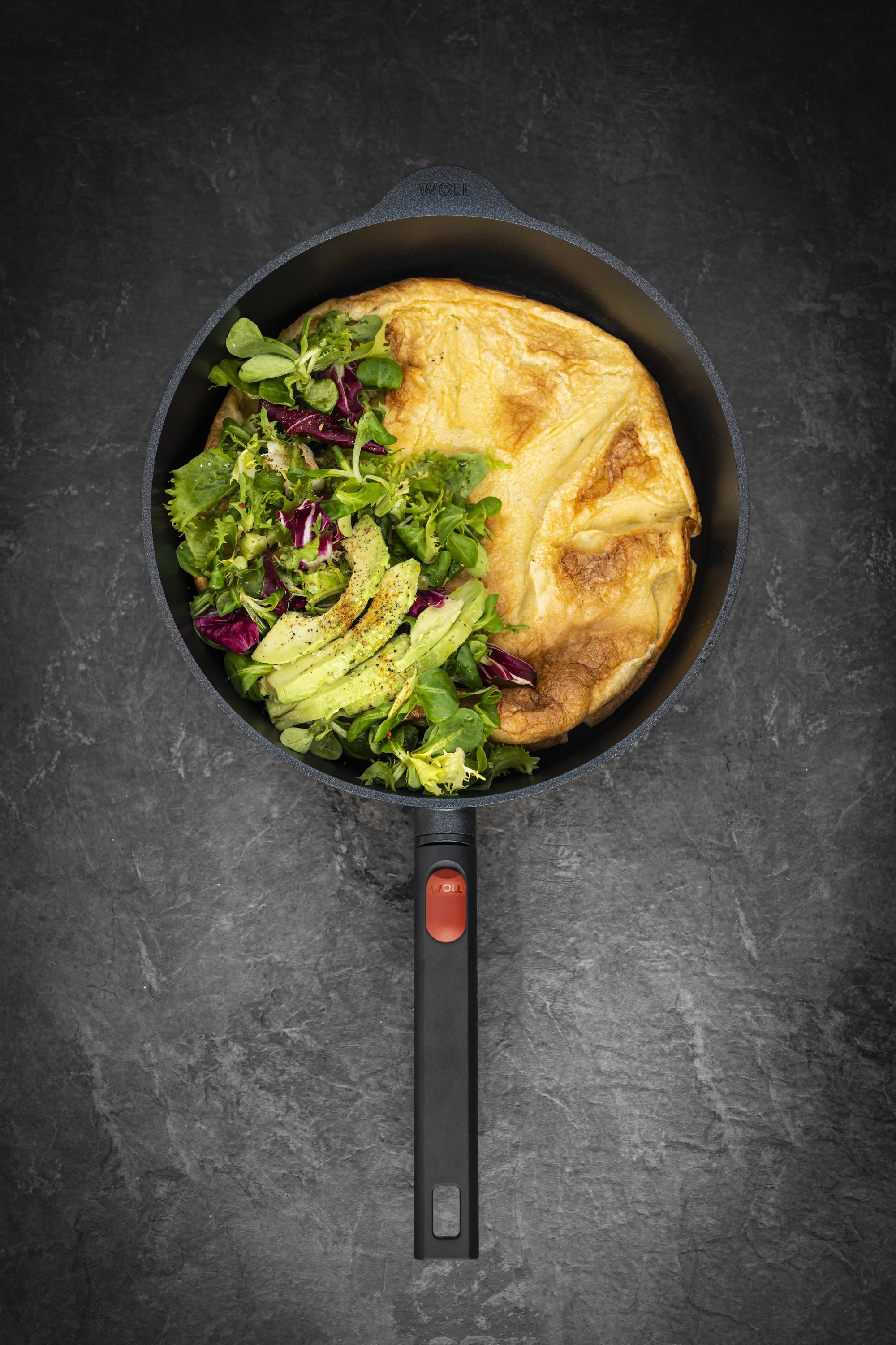Logic XR Guss-Hochrandpfanne In einer runden Logic XR Pfanne wurde ein Ofenpfannkuchen zubereitet und mit Salat und Avocado angerichtet.