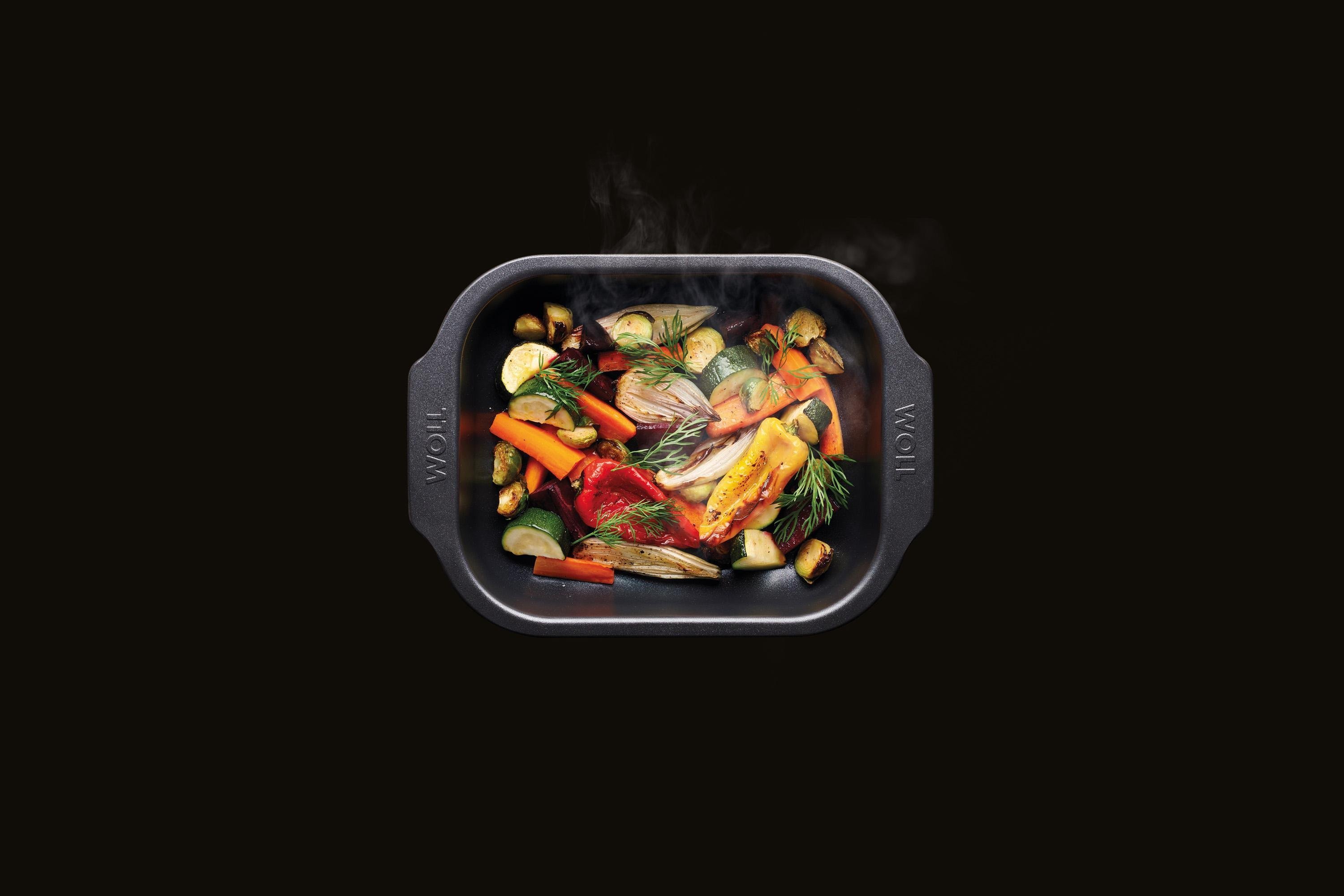 In einer rechteckigen Roast it! Bratreine befindet sich angeröstetes dampfendes Gemüse. 